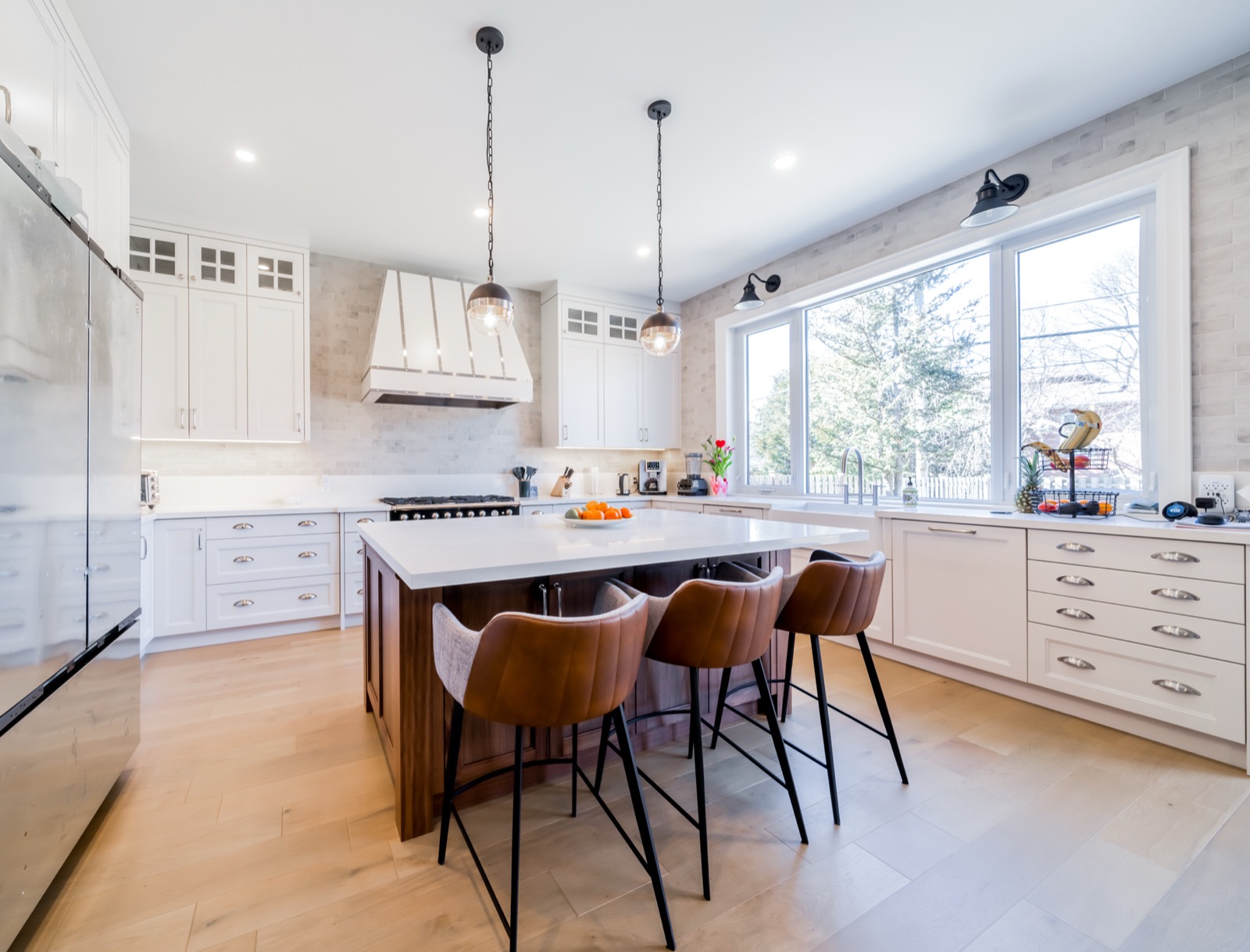 White shaker kitchen with walnut island and leather stools