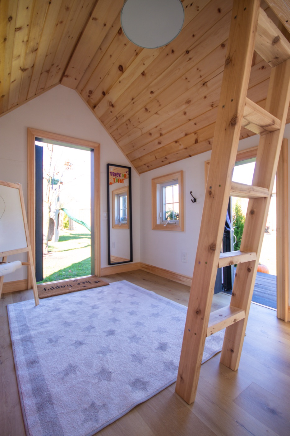 Playhouse interior with pine cathedral ceiling and loft ladder